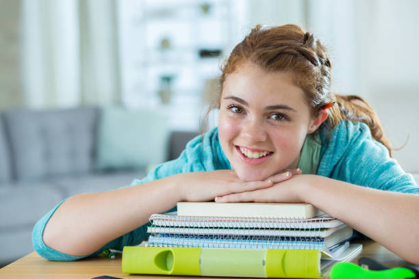 istock Teenager leans on a stack of books 827750898