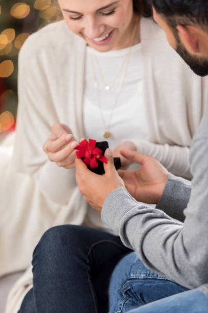 istock Young woman opens a gift on Christmas Eve 827751164