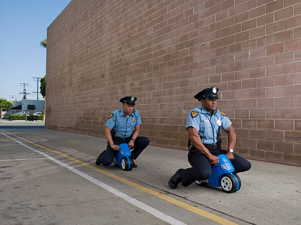 männer in polizei-uniformen auf spielzeug motorrad - police power stock-fotos und bilder
