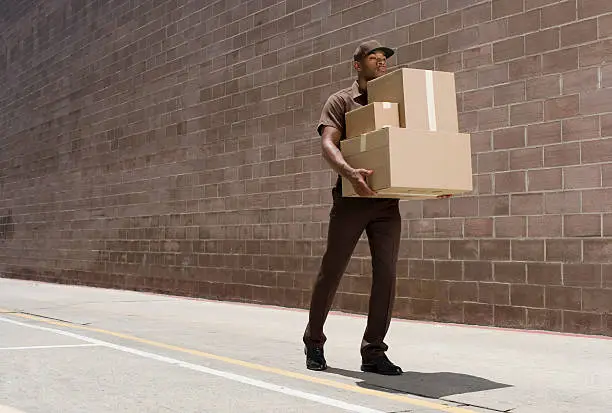 Photo of delivery-person carrying boxes