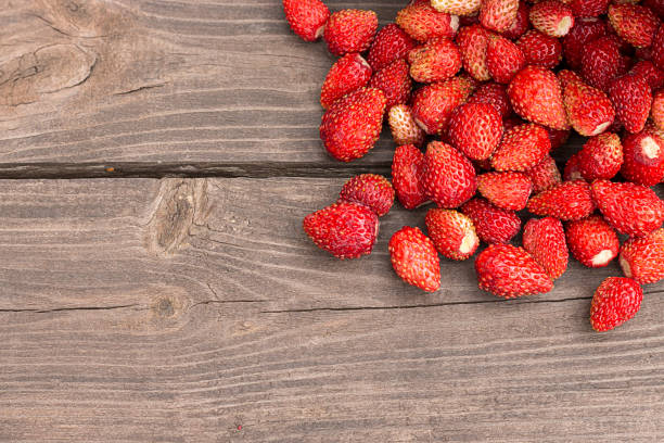 istock Wild strawberries on rustic wooden background 827758798