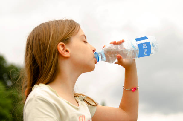 istock Child drinking water. Girl outdoor 827762706