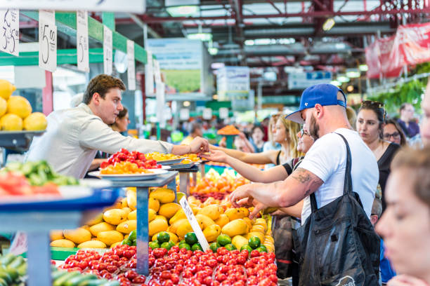 サンプル購入して生成果物と野菜に立っているコイン変更とジャン タロン ファーマーズ ・ マーケット - farmers market montreal canada market ストックフォトと画像