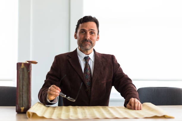 istock Smiling Businessman Holding Glasses and Posing for Camera 827780508
