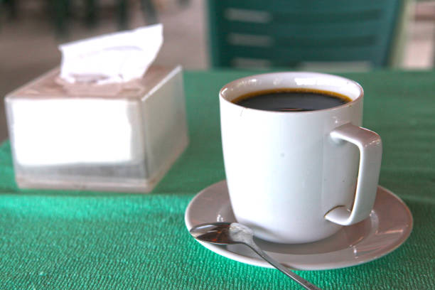 istock hot black coffee cllose up photo with teaspoon and tissue pack 827780710