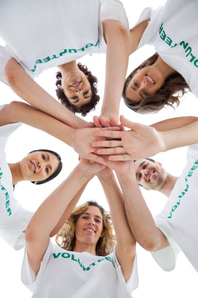 istock Smiling group of volunteers piling up their hands 827783750