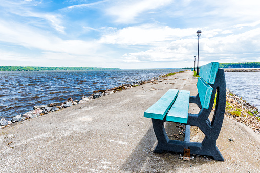 Empty blue bench overlooking St Lawrence river in Quebec, Canada during summer