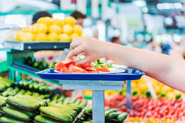 トマトのために達する女性の手は、農夫の市場でサンプルをスライスしま��す。 - farmers market montreal canada market ストックフォトと画像