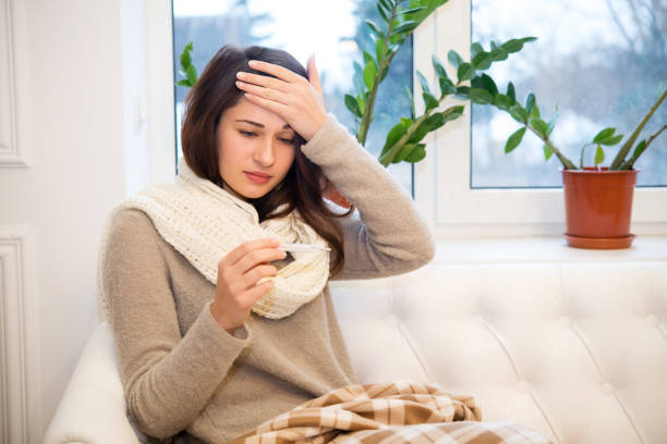 istock a cold girl checks her temperature 827793156
