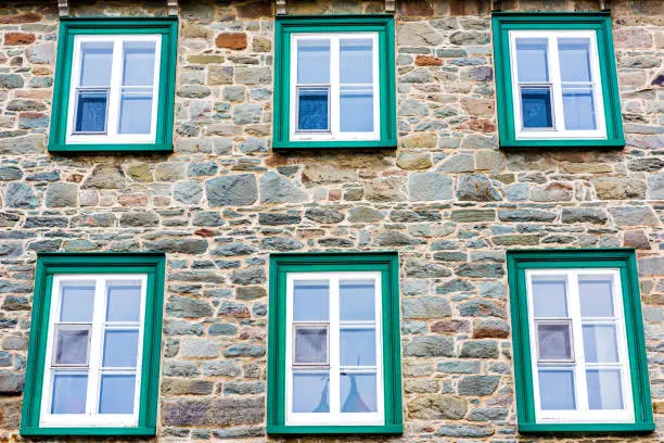 Closeup of european architecture stone building with green window frames