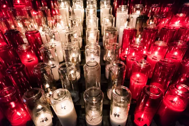 Red and white votive candles with yellow flame in church