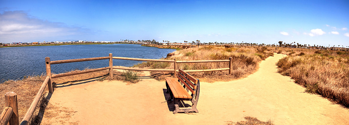 Bench overlooking the peaceful and tranquil marsh of Bolsa Chica wetlands in Huntington Beach, California, USA