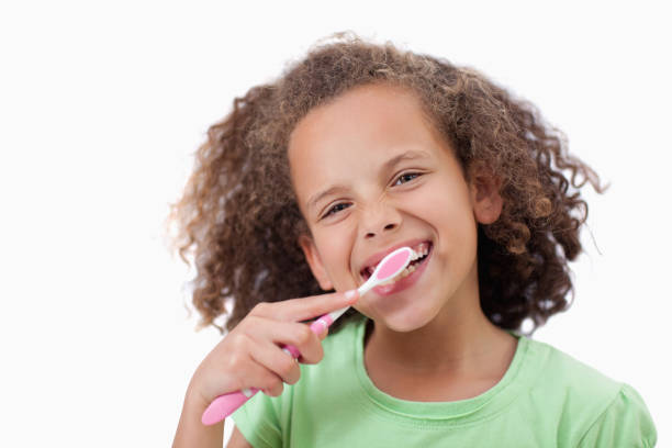 istock Smiling girl brushing her teeth 827799388