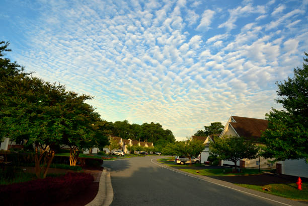 Residential Street Under a Buttermilk Sky An over 55 community with private residences awakens under a Mackerel or Buttermilk sky on a bright sunny morning on Maryland's easter shore cirrocumulus stock pictures, royalty-free photos & images
