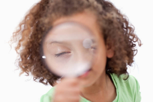 istock Cute girl looking through a magnifying glass 827799468