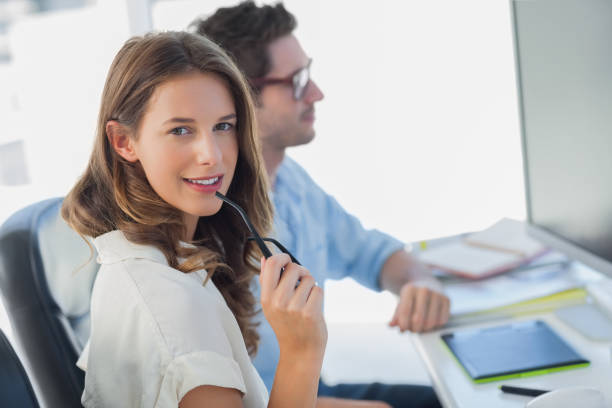 istock Attractive photo editor biting her reading glasses 827804064