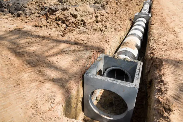 Concrete drainage pipe and manhole on construction site.