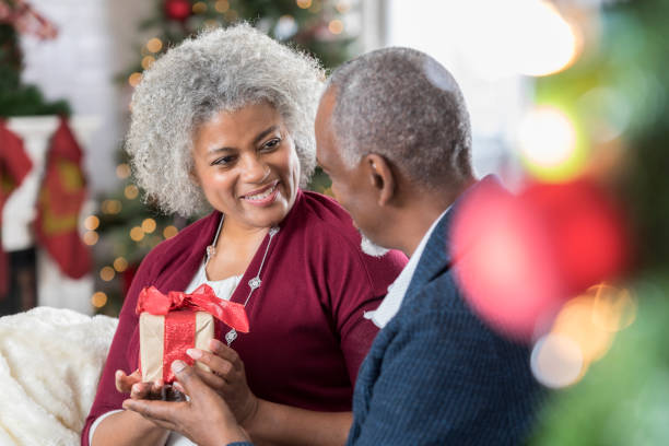 istock Senior woman accepts Christmas gift from husband 827810374