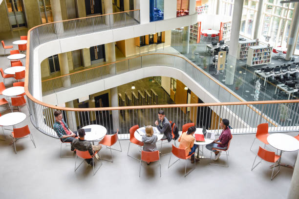 High angle view of modern college interior, students sitting around tables