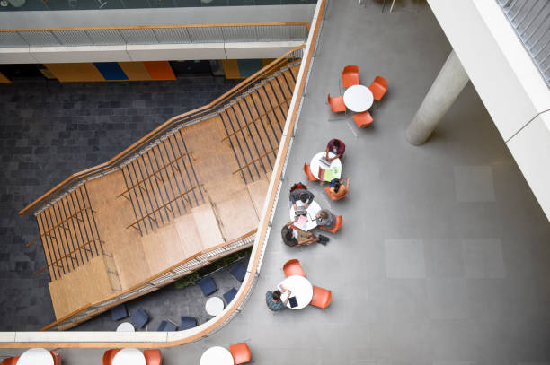 istock Overhead view of modern open plan college interior with tables and staircase 827810720