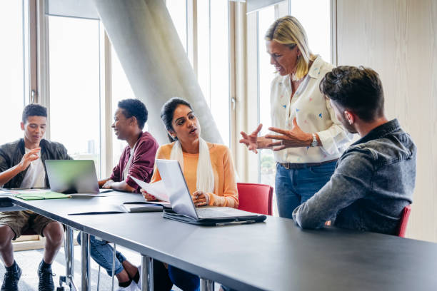 istock College lecturer explaining to small group of students in classroom 827810772