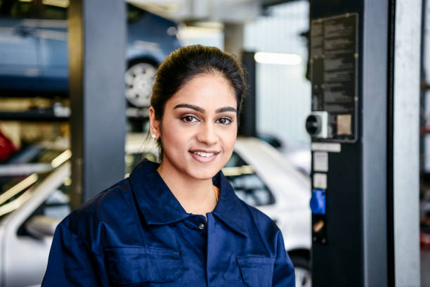 portrait of young female mechanic in garage - trainee mechanic engineer student imagens e fotografias de stock