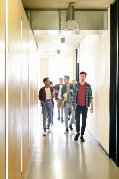 istock College students in corridor walking towards camera 827810850