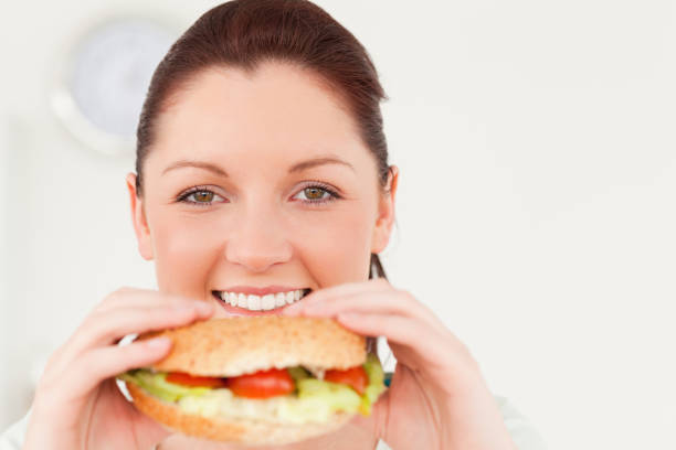 istock Good looking woman eating a sandwich for lunch 827814694