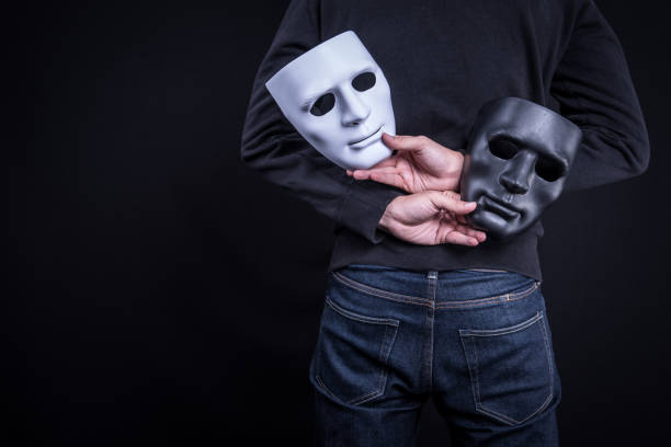 Mystery man holding black and white mask. Anonymous social masking concept. Mystery man holding black and white mask. Anonymous social masking concept. synthetic identity theft stock pictures, royalty-free photos & images