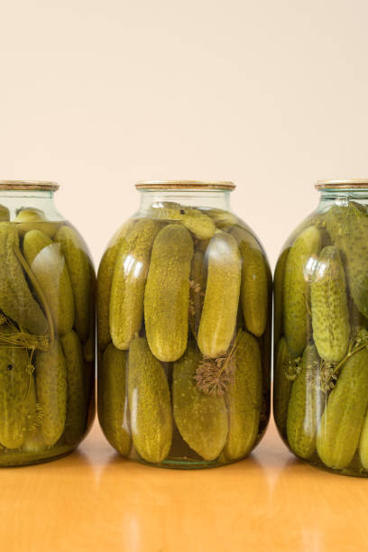 istock Pickled cucumbers on wooden table 827817500