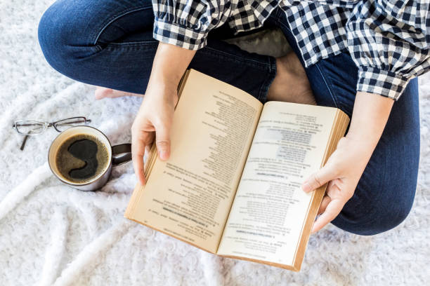 istock Woman with cup of coffee reading a book 827818302