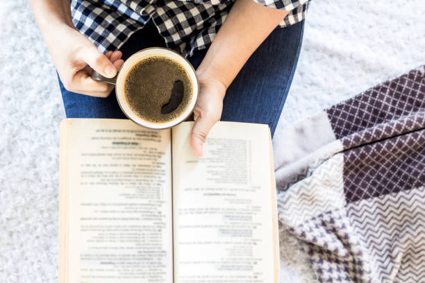istock Woman with cup of coffee reading a book 827818312