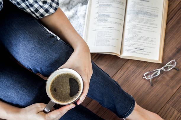 istock Woman with cup of coffee reading a book 827818314