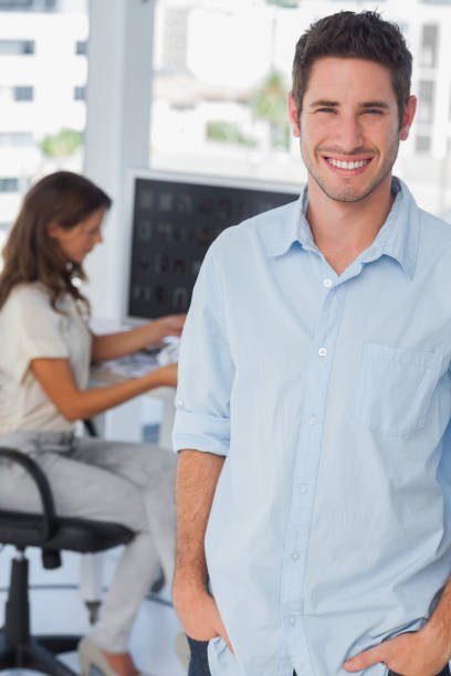 istock Handsome photo editor standing with hands in pocket 827821448