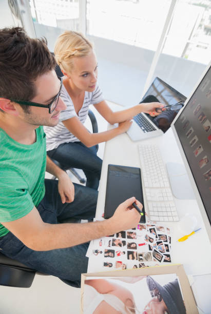 istock Cheerful photo editors working together on graphics tablet 827822208