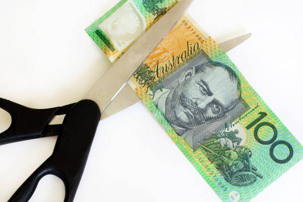 Australian Dollar Cut Australian dollars cut with scissors. budget cut stock pictures, royalty-free photos & images