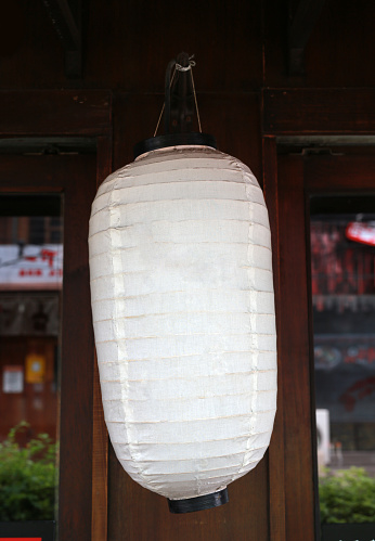 White paper lantern traditional japanese hanging on roof in the garden.