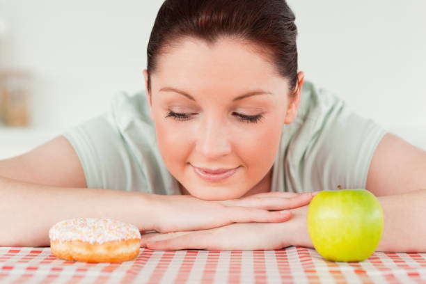istock Attractive woman posing with a donut and a green apple 827829072