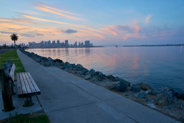 a bench welcomes anyone wishing to watch the glorious sunrises over Coronado Bay, San Diego, California stock photo