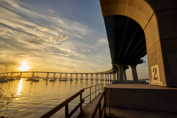 изогнутый мост коронадо на восходе солнца над заливом сан-диего - coronado bay bridge стоковые фото и изображения