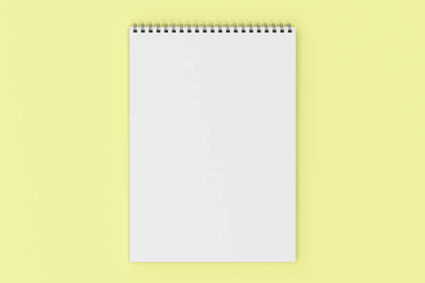 istock Blank white notebook with metal spiral bound on yellow background 827836996