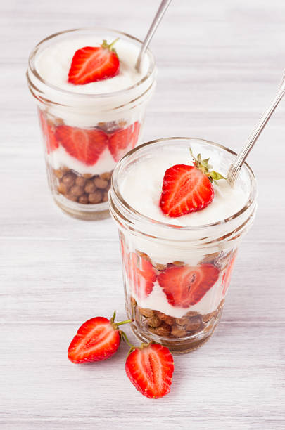 istock Breakfast with strawberry and chocolate balls corn flakes on white wood board. 827837568