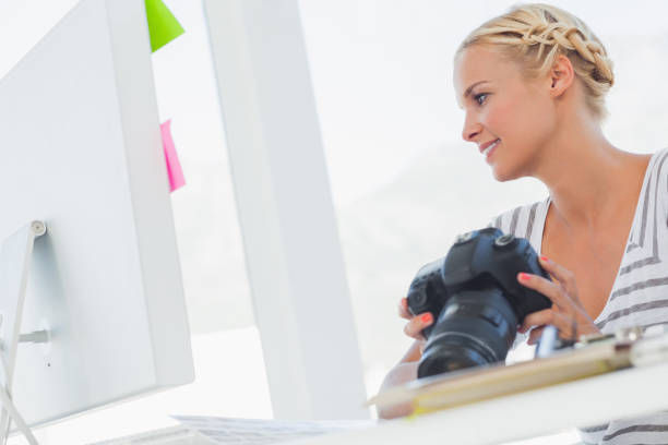 istock Attractive photo editor looking at a digital camera 827837604