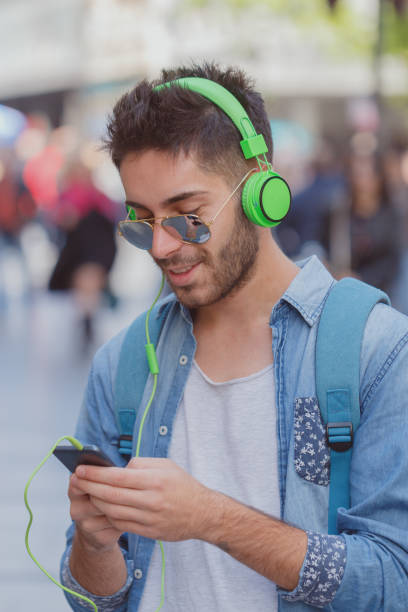 istock Smiling man texting and listening music 827842954