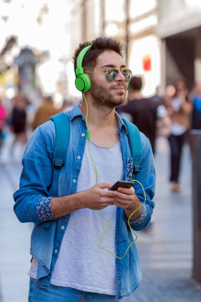 istock Smiling man texting and listening music 827843022