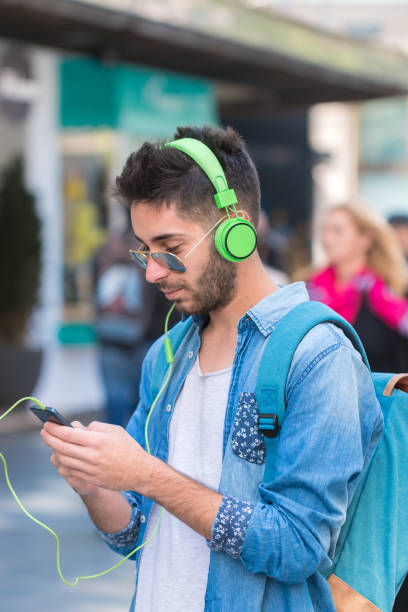 istock Smiling man texting and listening music 827843102