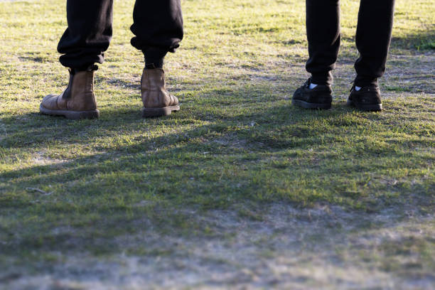 An Abstract Crop Of Two Side By Side Blue Collar Workers Feet And Boots stock photo