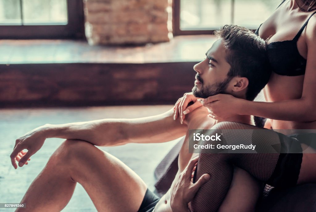 Sexy young couple Sexy young couple in underwear is posing on bed at home Sexual Issues Stock Photo