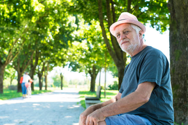 Side view of Senior sitting on bench in Park