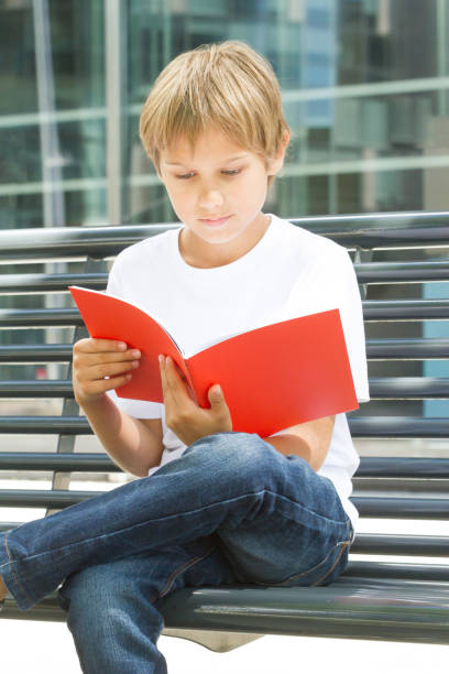 istock Child flipping through book pages outdoors 827859920